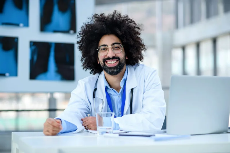 Smiling doctor at his desk in a modern clinic